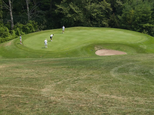 View down on the fifth green from in front of the Canadian flag